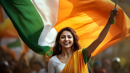 Mujer de pie morena con el brazo izquierdo levantando una bandera de la india celebrando el día de la republica de India. - obrazy, fototapety, plakaty