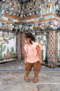 Adorable kindergarten girl wear Thai style costume travel in Wat Arun sightseeing