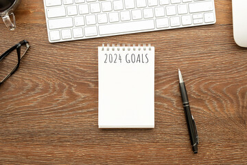 Notebook with 2024 goals text on it to apply new year resolutions and plan.
