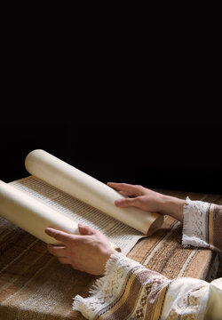 Hands hold an old scroll