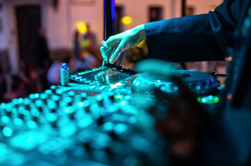 woman DJ Hands creating and regulating music on dj console mixer in concert