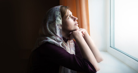 Girl praying by the window