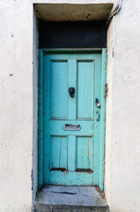 Pale blue wooden door on an abandoned house.