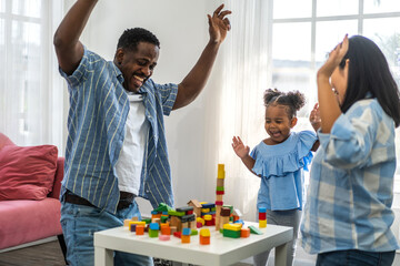 Portrait of happy love black family african american father and mother with little girl smiling activity learn and skill brain training play with toy build wooden blocks board education game at home