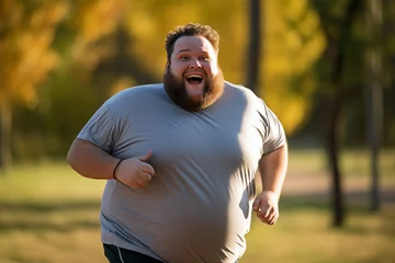 Poster Overweight or fat belly man smiling running with jogging park and outside morning sunset nature © PrettyStock