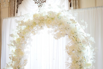 The photo zone is decorated with white artificial flowers.