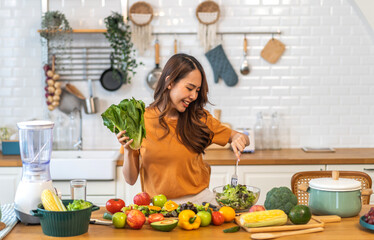 Portrait happy beauty slim healthy asian woman holding vegan food healthy fresh vegetable and fruit in kitchen.diet, vegetarian, eating, fruit, wellness, health, green food.Fitness, healthy food