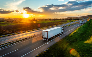 Large Transportation Truck on a highway road through the countryside in a beautiful sunset