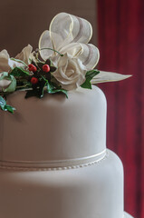 Ribbon and flowers on the top of a white iced wedding cake.