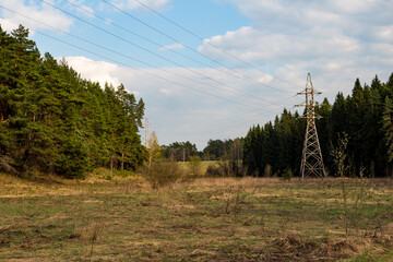 Power lines laid in a field between populated areas