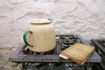 Main cast iron gas cooker from c1900-1920 with enamelled kettle and cookery book on hob