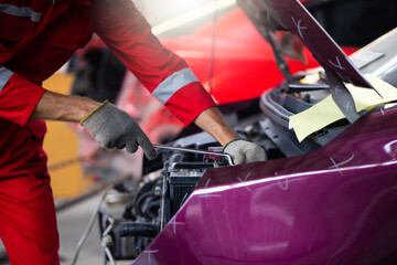 Caucasian male mechanic repairs car in garage. Car maintenance and auto service garage concept....