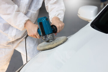 Fototapeta na wymiar Close up Hands with orbital polisher. Car polishing waxing. Auto mechanic car man worker working painting in car paint chamber. Body paint garage