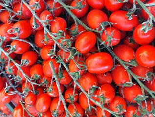 background of many red ripe cherry tomatoes on sale at the vegetable market