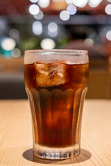 A glass of Cola on the table with bokeh background