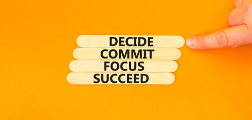 Decide commit focus succeed symbol. Concept word Decide Commit Focus Succeed on beautiful wooden stick. Beautiful orange background. Business decide commit focus succeed concept. Copy space.