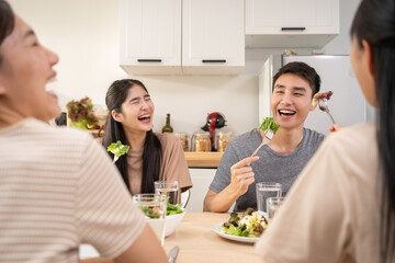 Happy Asian friends lunching with healthy food home- Young people having fun eating meal and...