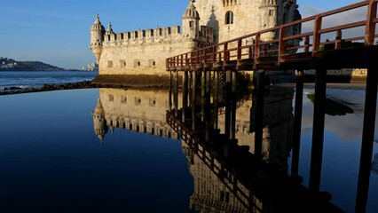 Belem Tower on Tagus River at sunrise in city of Lisbon, Portugal. Landmark fortification from the 16th century, tilt up view.