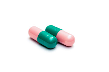 two green-pink capsules isolated on white bacground