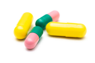 green-pink and yeloow capsules isolated on white bacground bokeh