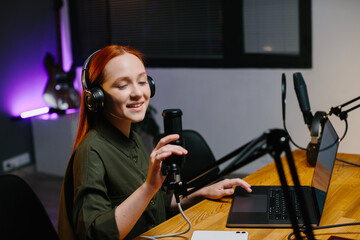Fototapeta na wymiar The girl Radio presenter communicates with listeners during the broadcast.