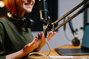 The girl radio presenter speaks into the microphone during the broadcast at the radio station....