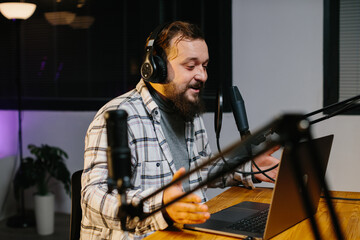 An online blogger speaks into a microphone during a stream. Radio presenter in the studio during...
