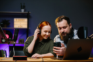 Online show hosts in a home studio. Online bloggers, with a phone in their hands, read the comments...