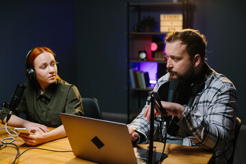 Talk show hosts are having a conversation in the studio while recording a new episode.