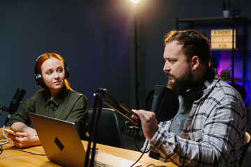 Talk show hosts are having a conversation in the studio while recording a new episode.