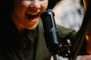 Close-up, dubbing actor or radio host speaking into a microphone.