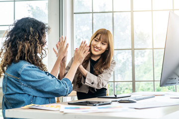 Collaboration of graphic design business people with computer in an office company. Two corporate women in creative marketing team working on project management , high five after a job is completed
