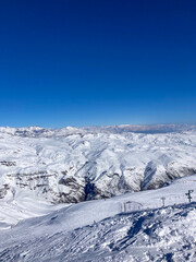 Fototapeta na wymiar Panoramic view of a majestic snow-covered mountain at a ski resort, with slopes ready for action.