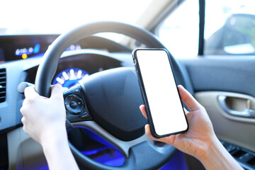 Mockup of woman driver hand using blank white screen mobile smart phone inside a car, searching...