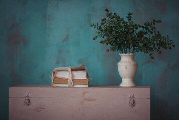 Vintage room decoration. Flower pots and books on blue wall background. Stylish and design composition of home decor on living room. Shabby old interior decor for farmhouse.