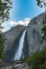 Vertical shot of the Yosemite Falls under blue sky in Yosemite National Park, California, USA