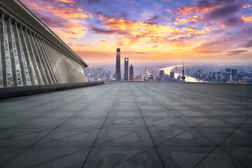 Square floor and city buildings skyline in Shanghai at sunset