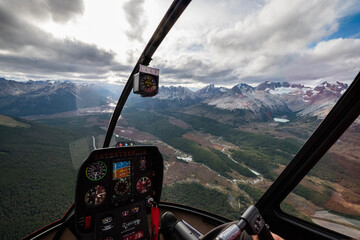 Aerial view of the mountains, rivers and valleys from the cabin of a small helicopter on a guided...