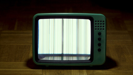 old tv monitor with damaged signal in dark room.
