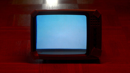 old vintage retro tv tube in dark room under red light, blank or empty tv monitor.