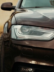 Vertical shot of a headlight of a shiny car
