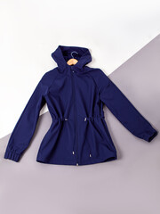 Dark blue women's jacket or windbreaker on hangers. Fitted jacket with hood. Top view