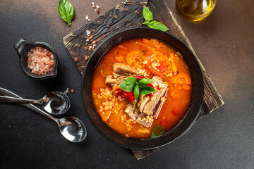 Homemade hot vegetable soup with bulgur, tomatoes and ribs on a dark background. top view. copy space for text