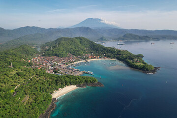 Naklejka premium Drone view of Bias Tugel Beach, Padangbai bay and Mount Agung on sunny day. Manggis, Bali, Indonesia.