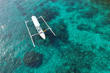 Aerial view of traditional Balinese boat (Jukung) in Blue Lagoon on sunny day. Padangbai, Bali,...