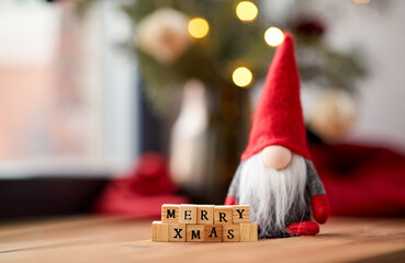 holidays, decoration and celebration concept - close up of merry christmas greeting on wooden toy...