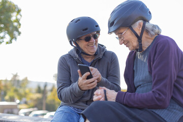 two elderly ladies sitting with bicycle helmets
