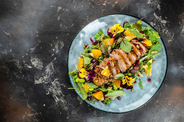 Healthy salad with duck meat, orange and vegetables on a dark background. top view. copy space for...