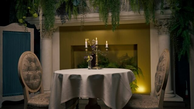  burning candles standing in a candlestick on a table next to flowers in an Italian restaurant 