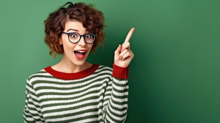 Photo of impressed funky girl dressed striped clothes eyewear pointing finger empty space isolated green color background 